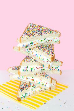 several pieces of cake with sprinkles on a yellow and white striped napkin