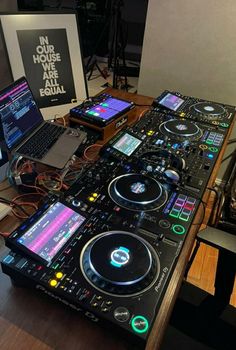 a laptop computer sitting on top of a dj's desk next to some decks