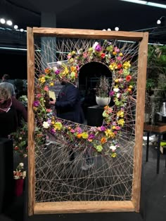 a man is standing in front of a display with flowers and plants on it's sides