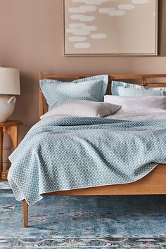 a bed with blue and white bedspread in a bedroom