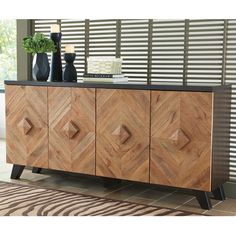 a wooden sideboard sitting on top of a rug