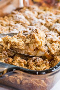 a close up of a spoon in a casserole dish with some crumbs on it