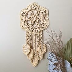 there is a wall hanging made out of macrament beads and other decorative items