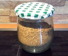 a jar filled with sand sitting on top of a counter