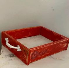 a red wooden box sitting on top of a table