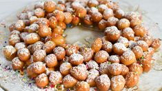 a cake covered in powdered sugar and sprinkles on a glass plate