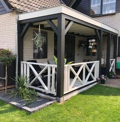 a house with a covered porch in front of it and plants on the back deck