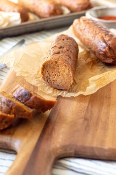 sliced sausages on wooden cutting board next to bread