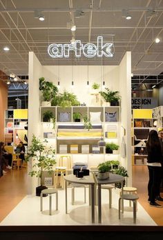 people are standing in front of a booth with plants