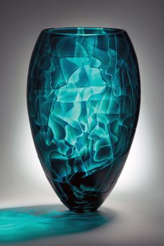 a blue glass vase sitting on top of a table