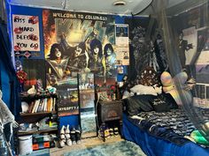 a bed room with a poster on the wall and posters all over the walls behind it