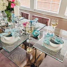 a glass table topped with plates and wine glasses