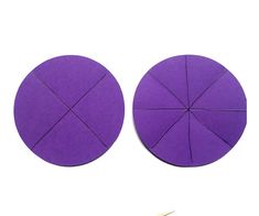 two circular pieces of purple paper next to a pair of scissors