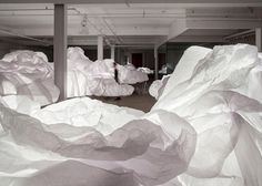 there are many large white rocks in the room that look like they have been made out of paper