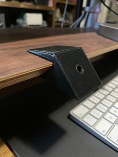 a wooden desk with a computer keyboard and mouse on it, next to a book shelf