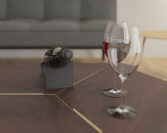 a glass of wine and a bottle on a table with a couch in the background