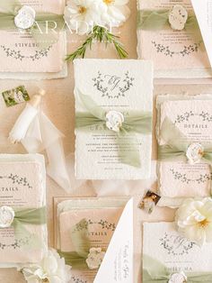 the wedding stationery is laid out on top of each other with flowers and ribbons