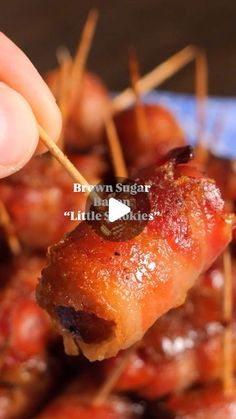 bacon wrapped in toothpicks being held up to show the meat on the skewer