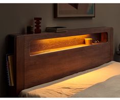 a bed with a wooden headboard and light under it