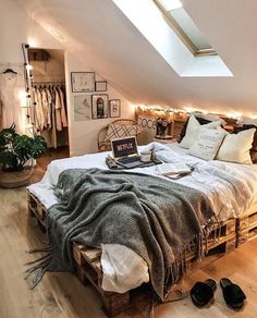 an attic bedroom with a bed made out of wooden pallets and lots of lights