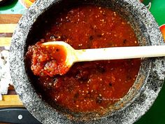 a wooden spoon in a bowl filled with sauce