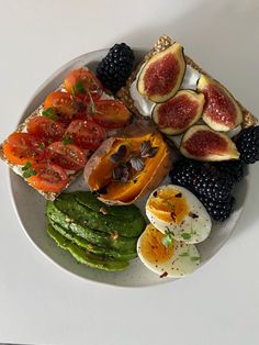 a white plate topped with different types of fruits and vegetables next to an egg shell