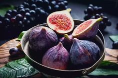 figs and grapes in a bowl on a wooden table