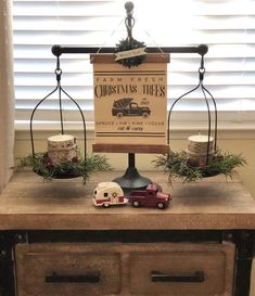 a wooden table topped with a scale and two figurines on top of it