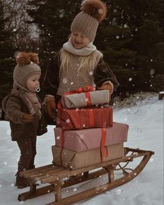 two children are pulling a sleigh with presents on it