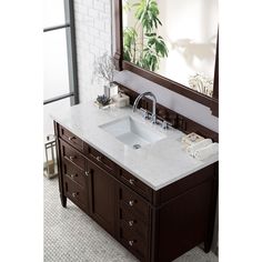 a bathroom sink sitting under a mirror in front of a counter top with drawers underneath it