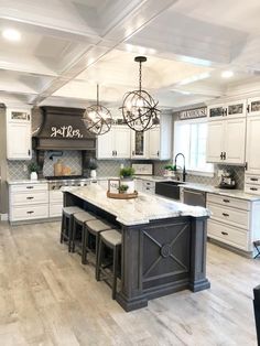 a large kitchen with white cabinets and an island