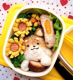 a bowl filled with food on top of a yellow tray next to a fork and knife