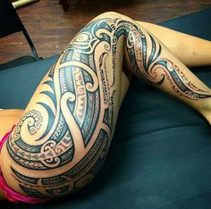 a woman laying on top of a bed covered in tattoos