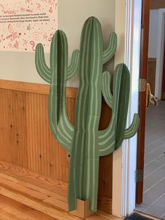 a large green cactus sitting on top of a wooden floor next to a door way