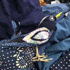 a bird is sitting on top of some blue fabric with gold dots and polka dots