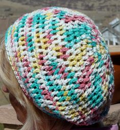 a close up of a person wearing a crocheted hat with multicolored yarn