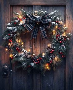 a christmas wreath with lights and pine cones hanging from the front door, on a wooden door