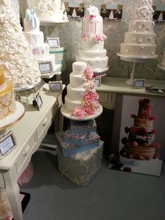 there are many different types of wedding cakes on the shelves in this store, including one for each tier