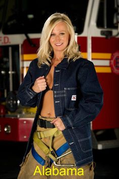 a beautiful blond firefighter posing in front of a fire truck with her shirt open