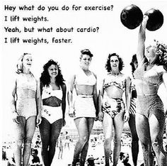 four women in bathing suits standing on the beach, one holding up a weight bar