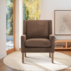 a brown chair sitting on top of a wooden floor next to a white area rug