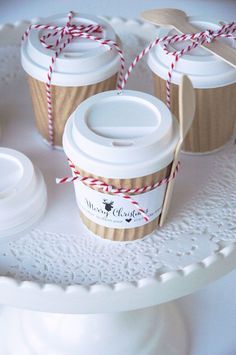 three coffee cups are wrapped in twine and sitting on a cake plate with two lids