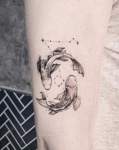 a woman's arm with a tattoo on it that has two koi fish swimming in the water