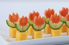 cucumber and cheese appetizers with watermelon on them are displayed on a white plate