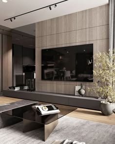 a living room with a large television mounted on the wall and a coffee table in front of it