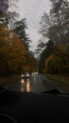 rain is falling down on the windshield of a car