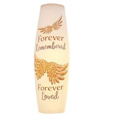 a white vase with gold lettering and an eagle on the bottom that says forever remembers forever loved