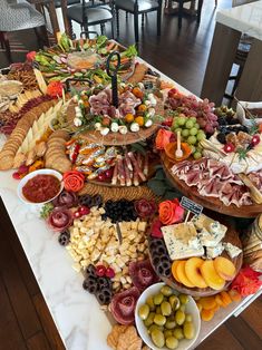 a table filled with lots of different types of food on top of a white counter