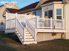 a house with white railings and stairs leading to the second story door that leads to another home