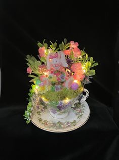 a teacup filled with flowers and lights